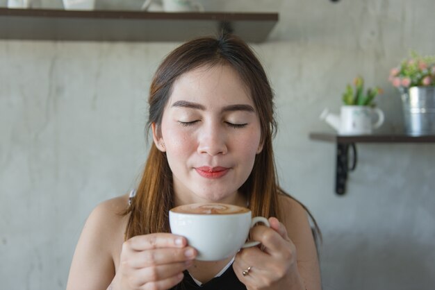 Frischer heißer Kaffee des schönen asiatischen Frauengeruches in einer Kaffeestube