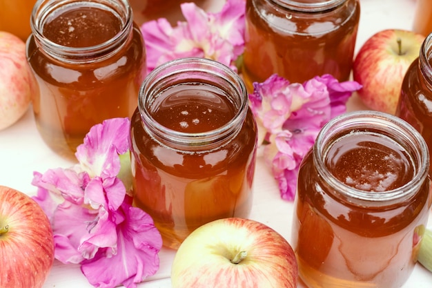 Frischer Honig im Glas auf hellweißem Holzhintergrund.