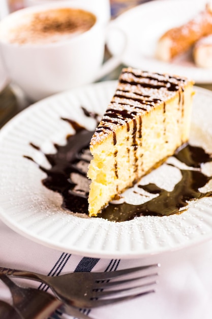 Frischer italienischer Bailey's-Käsekuchen mit Kaffee auf dem Tisch.