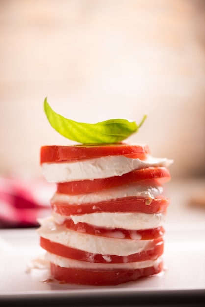 Frischer italienischer Caprese-Salat mit geschnittenem Mozzarella und Kräutern