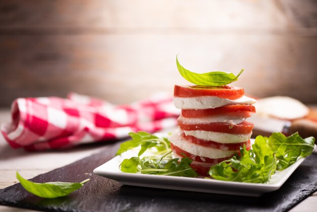 Frischer italienischer Caprese-Salat mit geschnittenem Mozzarella und Kräutern