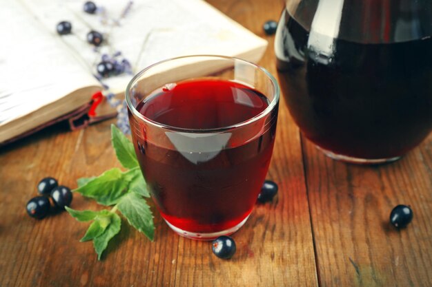 Frischer Johannisbeersaft mit Beeren und Buch auf dem Tisch aus nächster Nähe