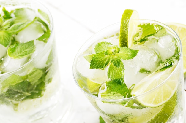 Frischer kalter Limettenmojito auf weißem Tisch