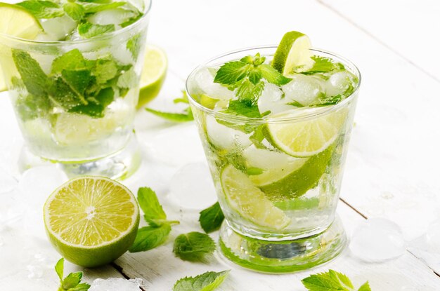 Frischer kalter Limettenmojito auf weißem Tisch