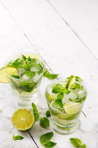 Frischer kalter Limettenmojito auf weißem Tisch