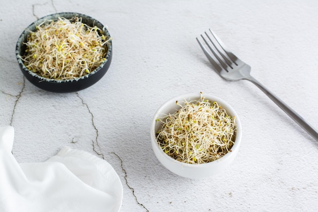 Foto frischer klee und alfalfa-sprossen für lebensmittel in einer schüssel auf einem leuchttisch detox-bio-diät