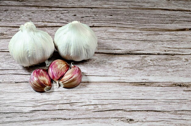 Frischer Knoblauch auf einem rustikalen Holztisch. Knoblauchzehen.