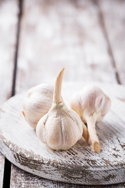 Frischer Knoblauch auf hellem hölzernem Hintergrund