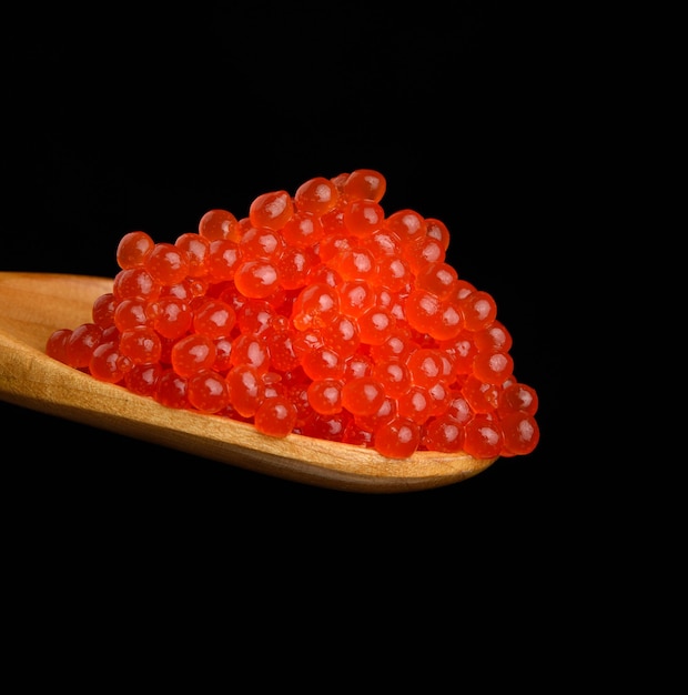 Frischer körniger roter Kumpel-Lachskaviar in einem Holzlöffel, köstliches und gesundes Essen, Nahaufnahme