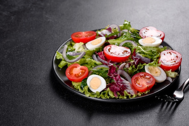 Frischer köstlicher vegetarischer salat des gehackten gemüses auf einem teller auf einem dunklen betonhintergrund