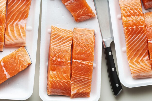 Frischer Lachs in Stücke geschnitten und bereit zum Kochen von Fischschneiden und einem großen Kochmesser