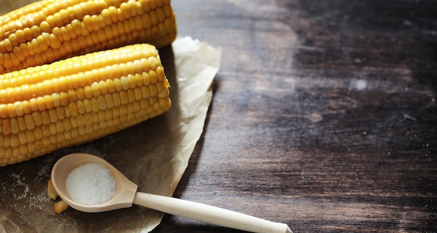 Frischer Mais. Naturkost aus Maiskolben mit Salz. Ländliches mexikanisches Essen. Gesundes Essen. Gekochte und gebratene Maiskolben auf Holztisch werden mit Salz serviert.