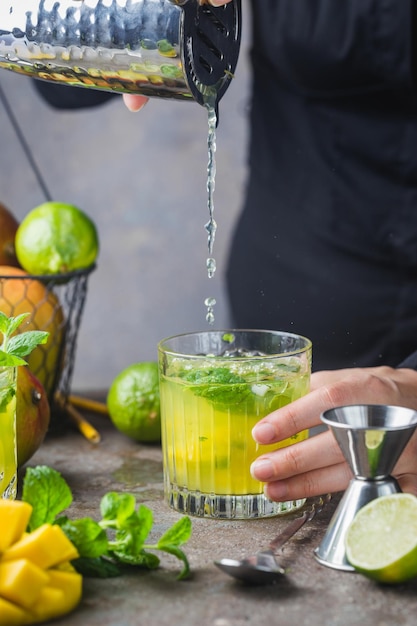 Frischer Mango-Mojito-Cocktail mit Limette und Minze im Glas