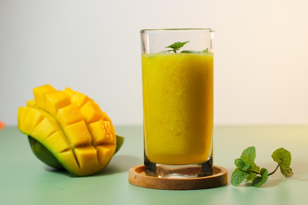 Frischer Mangosaft Serviert mit einer natürlichen grünen Hintergrundfarbe zusammen mit geschnittener Arumanis-Mango