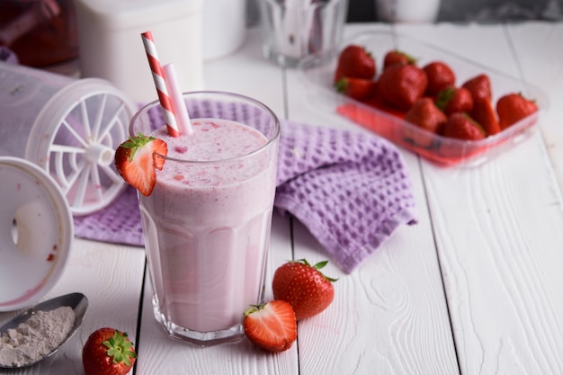 Frischer Milchshake mit Erdbeeren auf einem Leuchttisch.