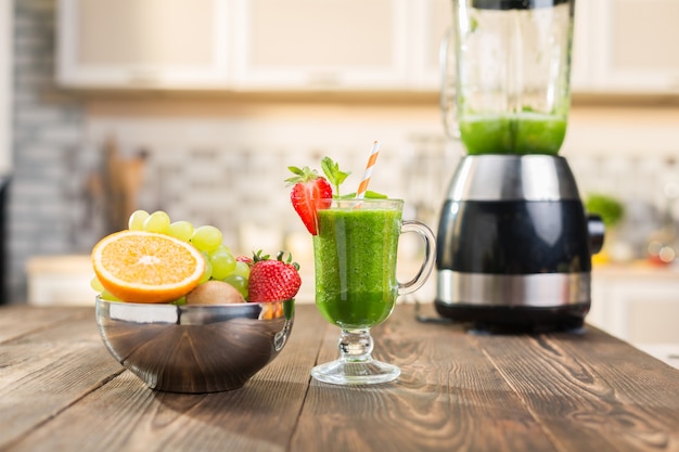 Frischer Obst- und Gemüsesmoothie auf Küchentisch im Glas