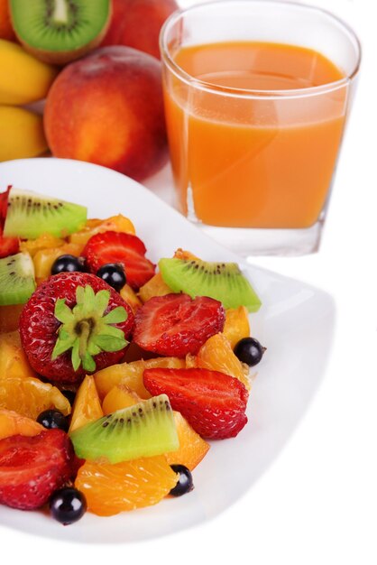 Frischer Obstsalat auf Teller mit Beeren und Saft aus nächster Nähe