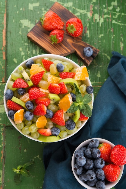 Frischer Obstsalat, Blaubeeren, Erdbeeren, Trauben, Kiwi, Orange. Ansicht von oben