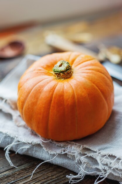 Frischer orange Kürbis auf Holztisch