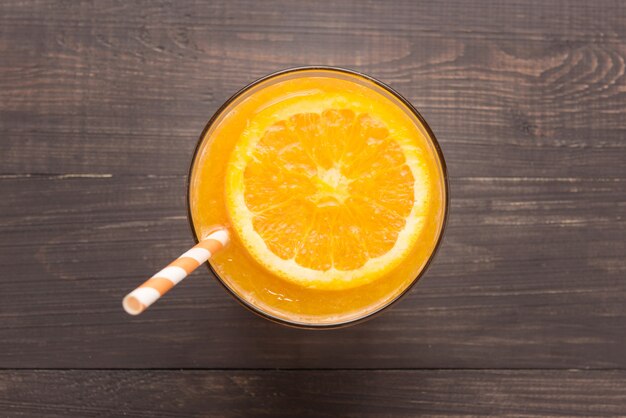 Foto frischer orangensaft im glas auf hölzernem hintergrund