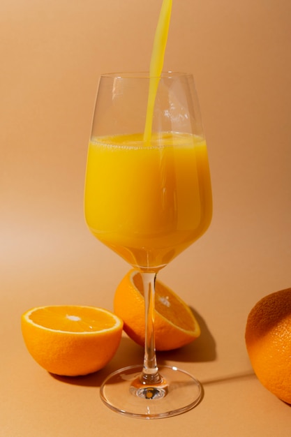 Frischer Orangensaft mit Fruchtfleisch in einem Weinglas auf Beige