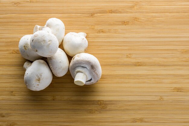 Frischer Pilzchampignon auf einem Holzbrett