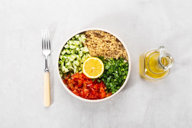Frischer Quinoa-Tabouleh-Salat in einem Teller mit Zitrone und Öl
