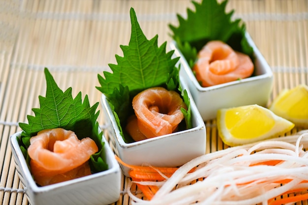 Frischer roher Lachsfisch zum Kochen von Lebensmitteln, Meeresfrüchten, Lachsfisch, Lachs-Sashimi-Essen, Lachsfilet, japanisches Menü mit Shiso-Perilla-Blatt, Zitronenkraut und Gewürzen