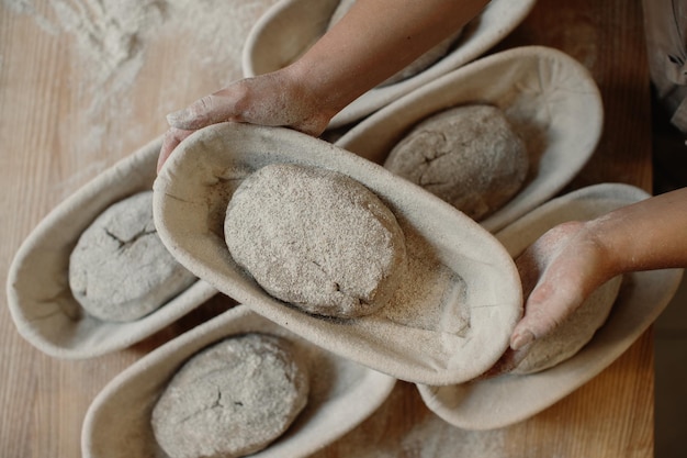 Frischer Rohteig in Holzformen auf dem Tisch vor dem Backen von hausgemachtem Brot