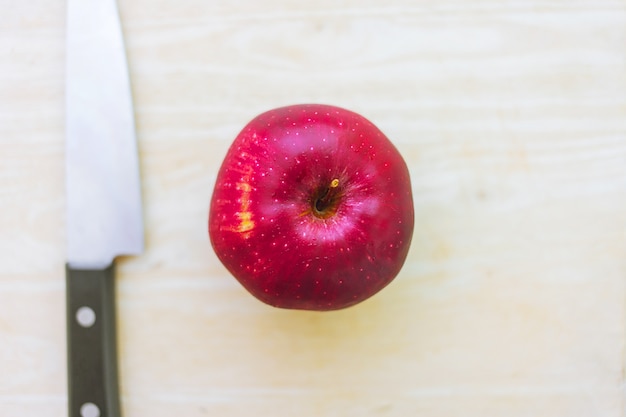 Frischer roter Apfel auf Holz mit Draufsicht des Küchenmessers