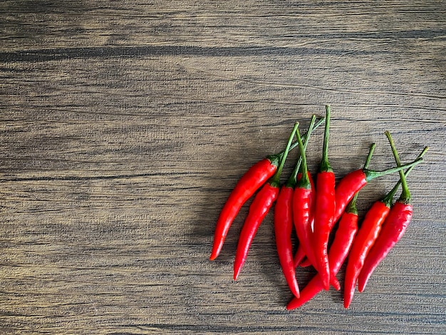 Frischer roter Chili und Platz für Text auf Holzhintergrund