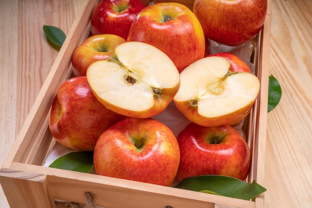 Frischer roter Neid-Apfel im Holzkorb auf Holzhintergrund Neid-Apfel auf Holzkistenverpackung