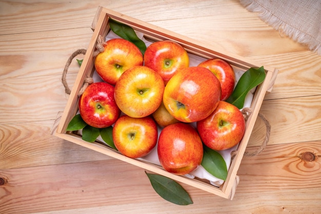 Frischer roter Neid-Apfel im Holzkorb auf Holzhintergrund Neid-Apfel auf Holzkistenverpackung