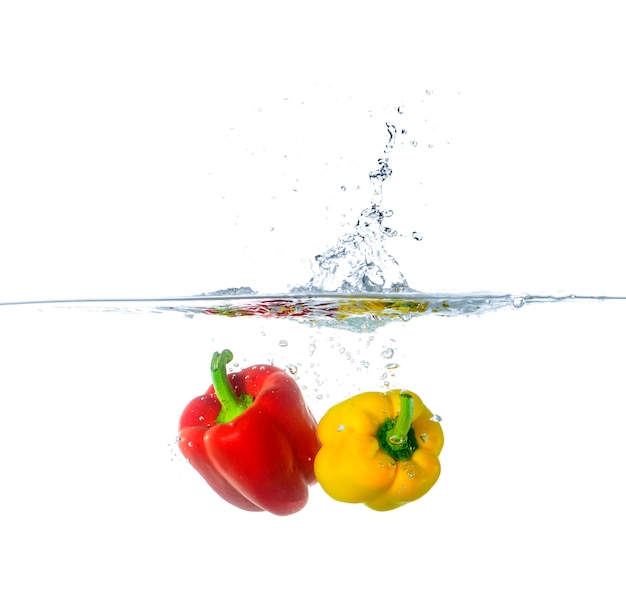 Frischer roter und gelber Paprika spritzt in Wasser