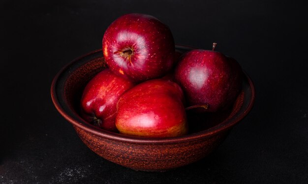 Frischer saftiger roter Apfel mit Wassertropfen gegen dunkle Oberfläche mit Platz für Text