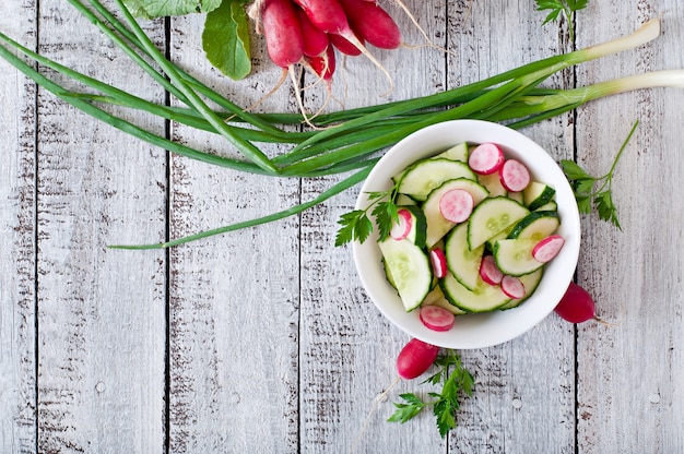 Frischer Salat aus Gurken und Radieschen in einer weißen Schüssel