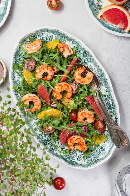 Frischer Salat mit Garnelen, Rucola, Tomaten und Zitrusfrüchten