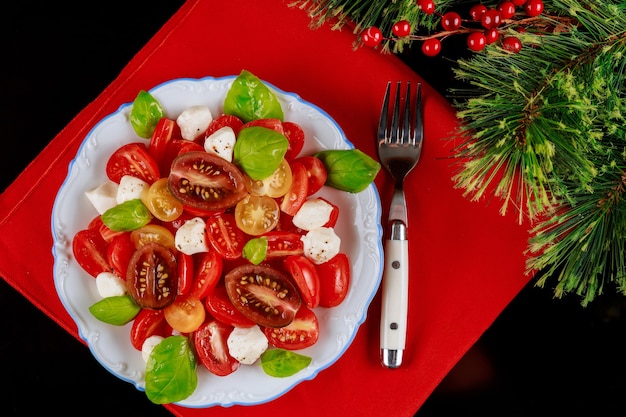 Frischer Salat mit Kirschtomaten, Gurken und Mozzarella. Weihnachtsessen Tisch.