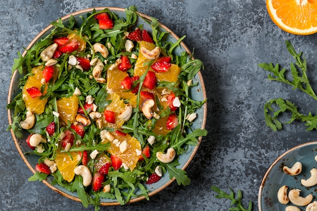 Frischer Salat mit Rucola, Früchten und Nüssen.