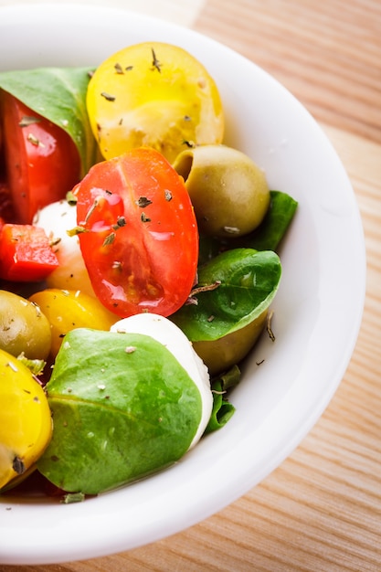 Frischer Salat mit Tomaten, Oliven und Mozzarella mit Gewürzen