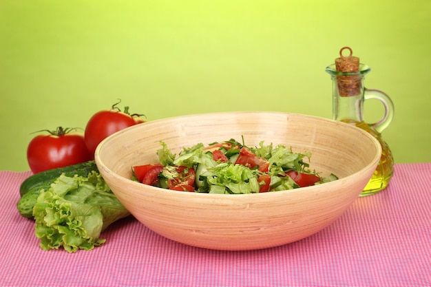 Foto frischer salat mit tomaten und gurken auf grünem hintergrund