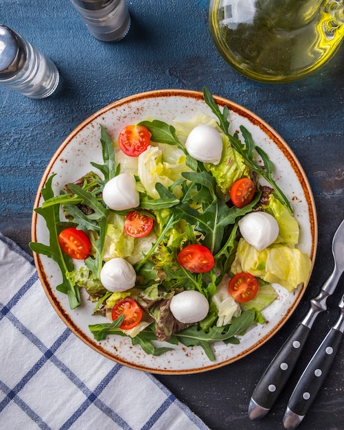 Frischer Salat Rucola, Salat, Kirschtomaten und Mozzarella. Ansicht von oben.