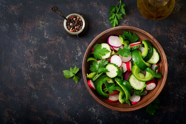 Frischer Salat von Gurken, Radieschen, Paprika und Petersilie. Flach legen. Draufsicht