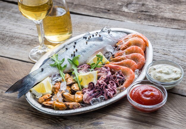 Frischer Seebarsch mit Meeresfrüchten auf dem Tablett