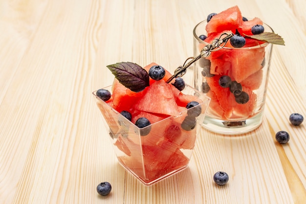 Frischer Sommerfruchtnachtisch. Süße Wassermelone und Blaubeere, purpurrote Basilikumblätter