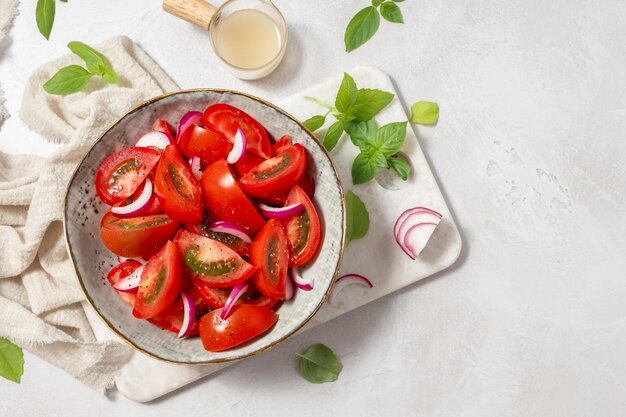 Foto frischer sommertomatensalat mit basilikum und zwiebel