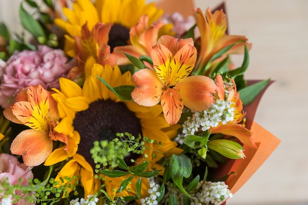 Frischer Strauß gelber Sonnenblumen und rosa Nelken auf Marmorhintergrund Blumenladen eine Variante von...