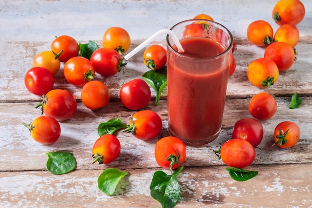 Frischer Tomatensaft mit Tomate auf hölzernem Fußboden