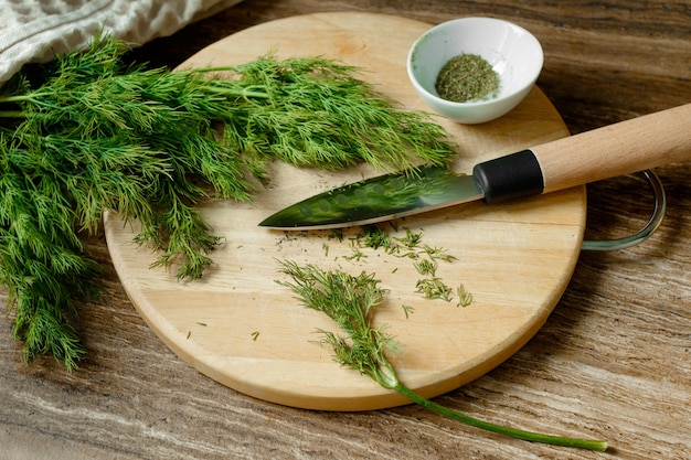 Foto frischer und getrockneter dill auf einem holzbrett