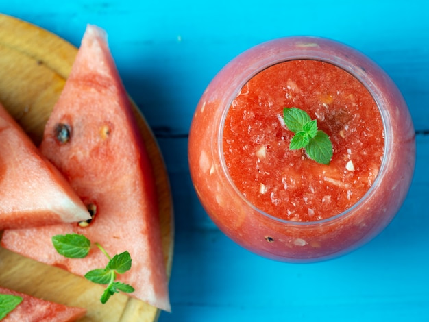 Frischer Wassermelone Smoothie auf hölzernem Blau.